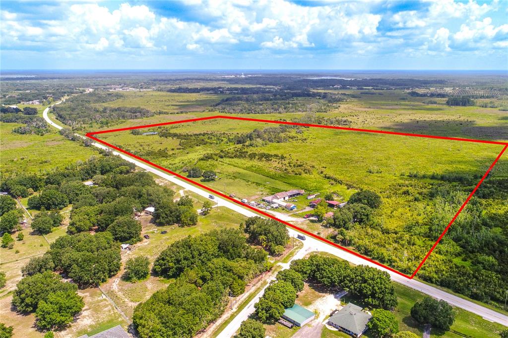 An aerial view shows a large, rectangular plot of land outlined in red near a road — 4706 COUNTY ROAD 557A, POLK CITY, FL