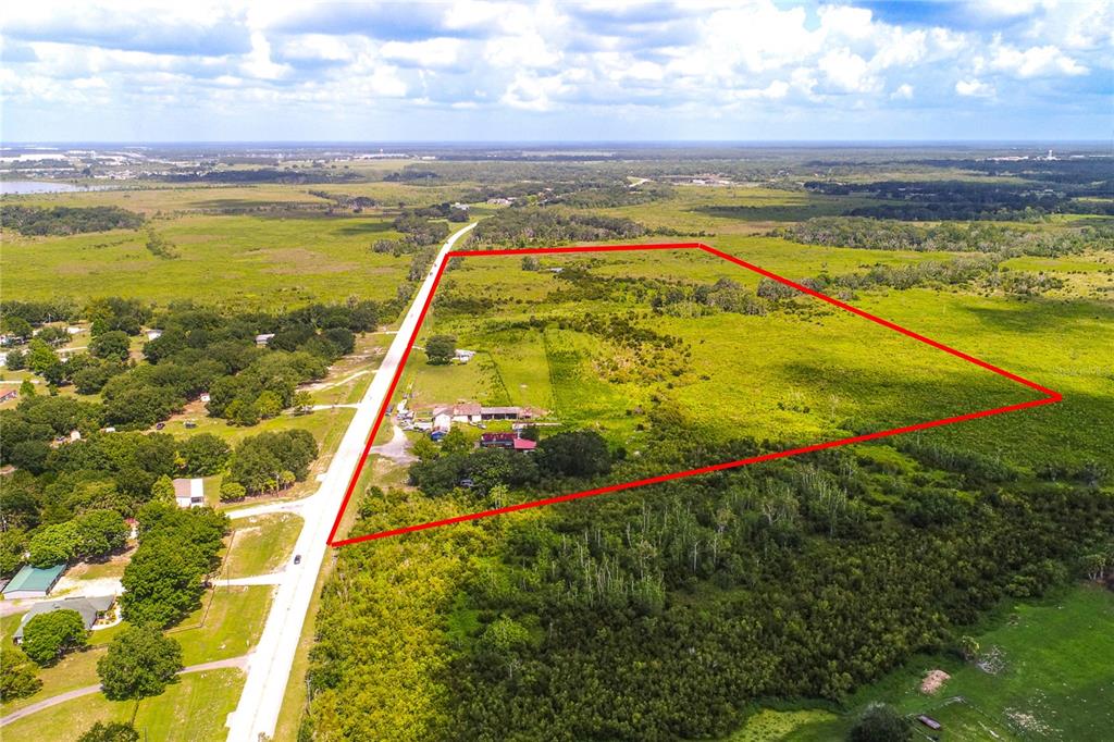 An aerial view shows a large, rectangular plot of land outlined in red beside a road — 4706 COUNTY ROAD 557A, POLK CITY, FL