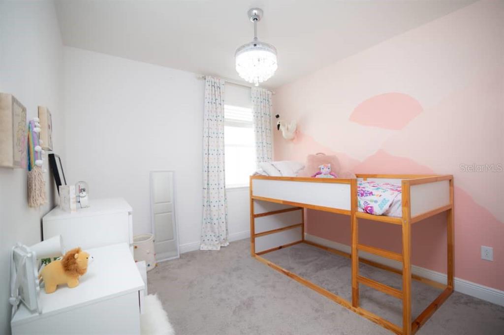 A child's bedroom features a loft bed, a pink accent wall, and a crystal chandelier — 15367 GILLIGAN COURT, WINTER GARDEN, FL