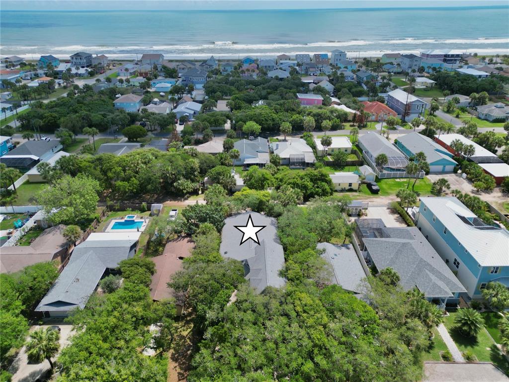 An aerial view shows a residential neighborhood with houses surrounded by trees near the ocean — 2023 S FLAGLER AVENUE, FLAGLER BEACH, FL
