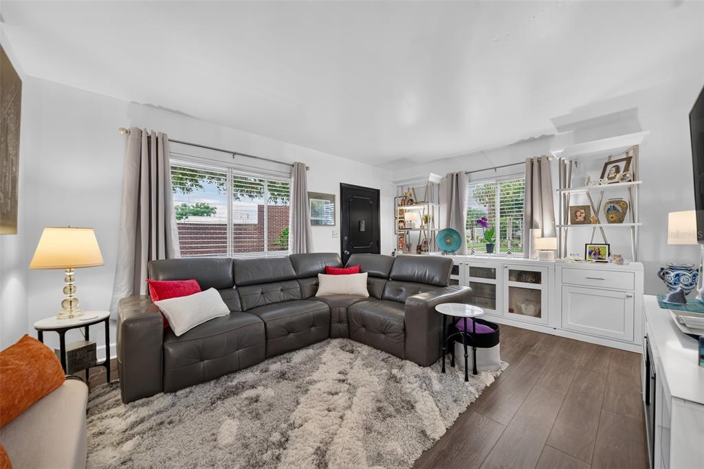 A living room features a gray sectional sofa, a shag rug, and white built-in shelving — 1140 S ORLANDO AVENUE UNIT E1, MAITLAND, FL