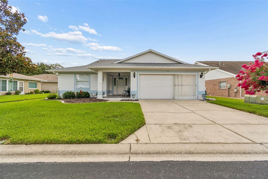 A single-story house with a white garage, covered entryway, and a green lawn — 6353 SILVER LAKES DRIVE W, LAKELAND, FL