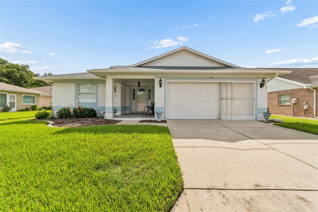 A single-story house with a white garage, light blue trim, and a front porch — 6353 SILVER LAKES DRIVE W, LAKELAND, FL