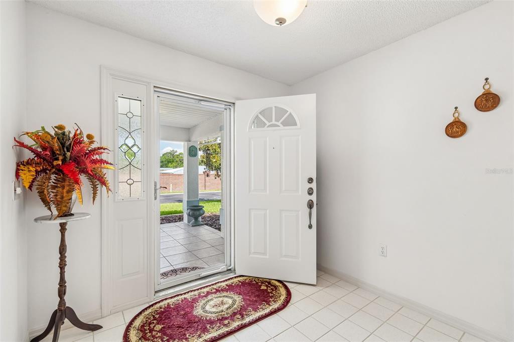 An entryway with white tile floors, a white front door, and a decorative rug — 6353 SILVER LAKES DRIVE W, LAKELAND, FL