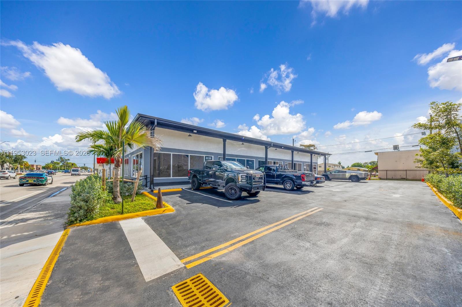 A commercial building with a parking lot and several trucks parked in front — 4030 Pembroke Rd, Hollywood FL 33021, HOLLYWOOD, FL