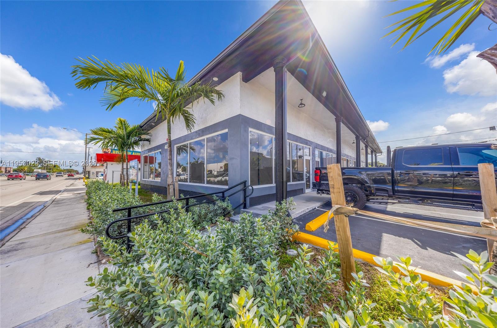 A modern commercial building with a dark trim exterior, large windows, and a parking area — 4030 Pembroke Rd, Hollywood FL 33021, HOLLYWOOD, FL