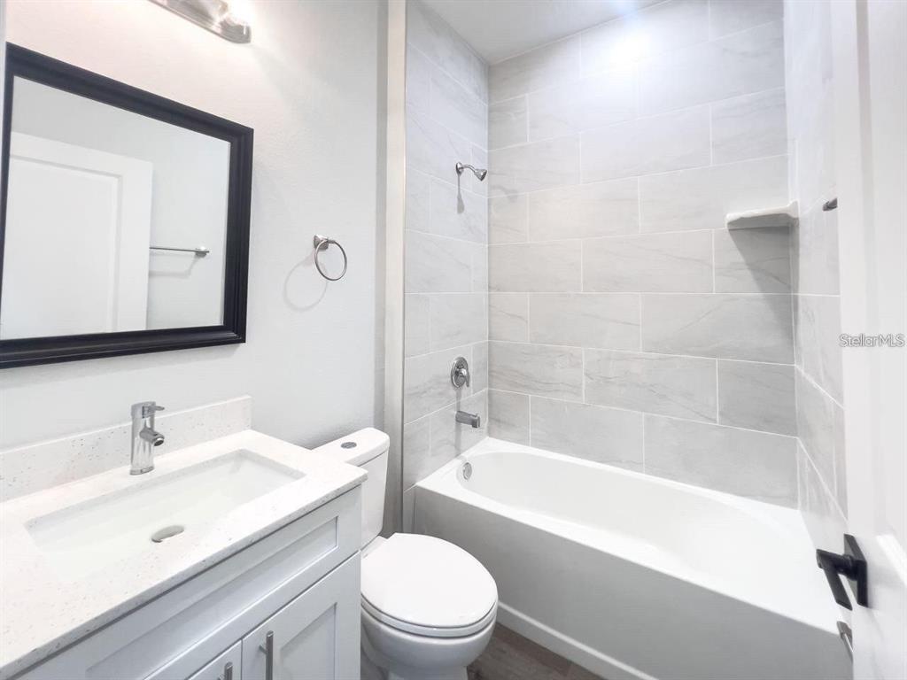 A bathroom features a white vanity, a toilet, and a tiled shower-tub combination — 35 PECAN RUN COURSE, OCALA, FL