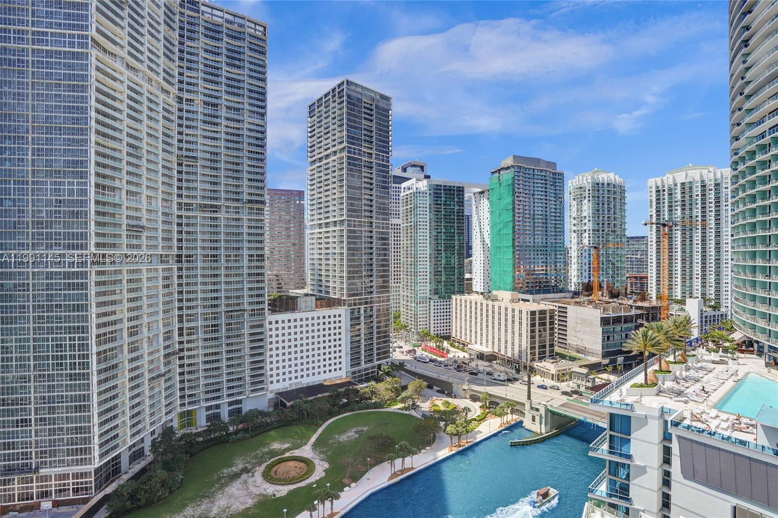 An elevated exterior view shows a city skyline with skyscrapers, a canal, and a park — 300 Biscayne Boulevard Way # 2106W, Miami FL 33131, MIAMI, FL