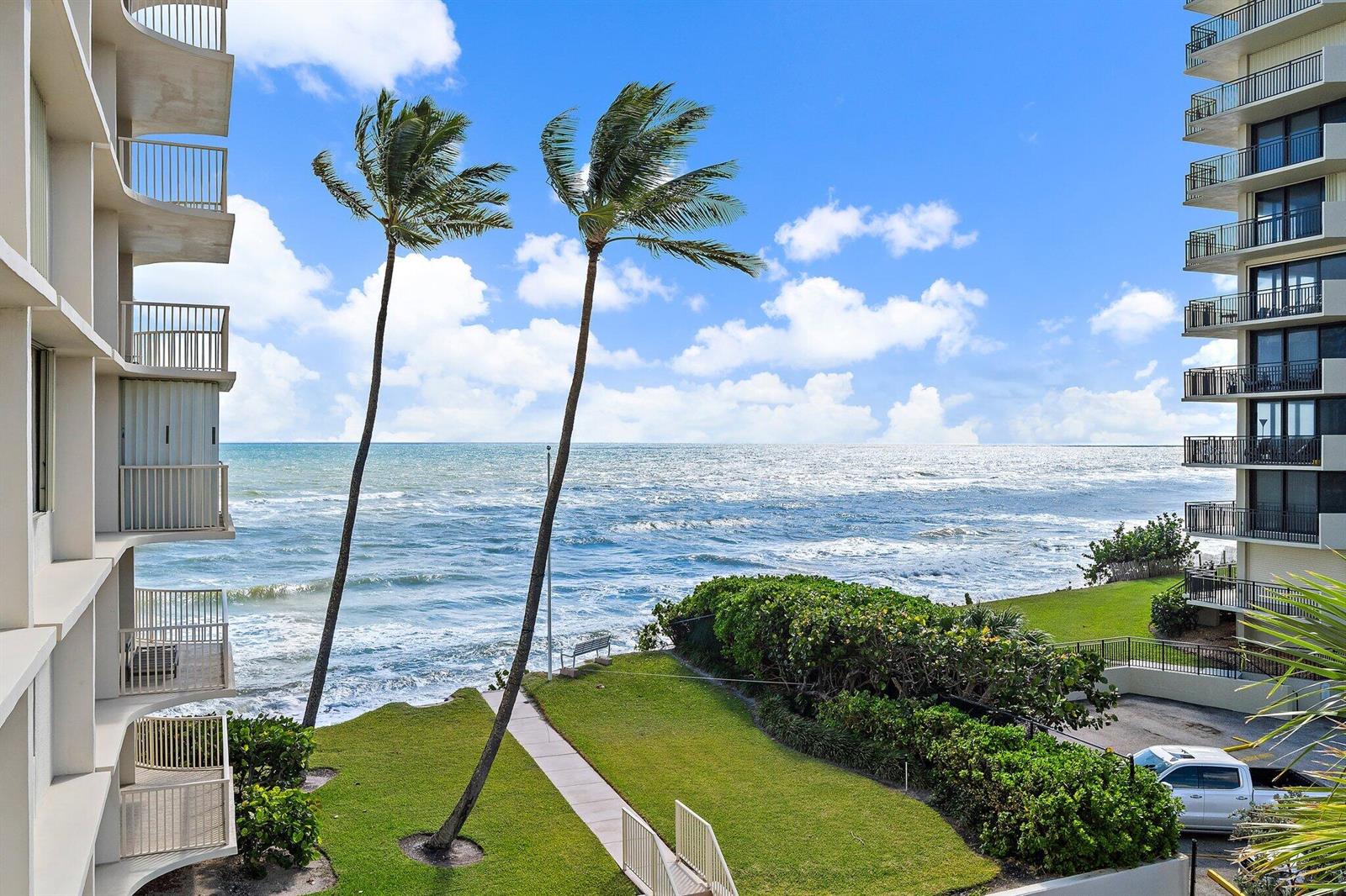 An exterior view of two high-rise buildings overlooking a grassy lawn and the ocean — 5480 N Ocean Drive, Singer Island FL 33404, SINGER ISLAND, FL