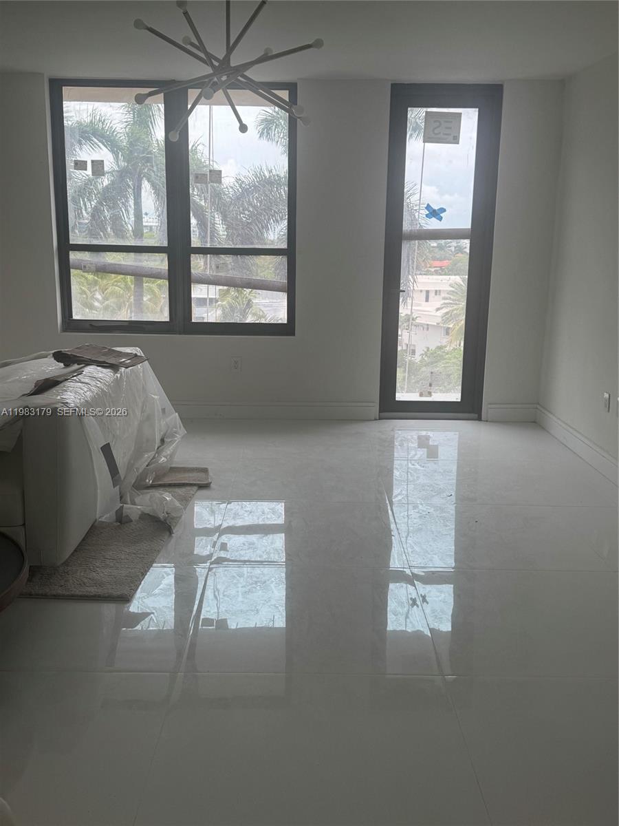 A bright, open-concept dining and living area features white tile flooring and recessed lighting — 10185 Collins Ave # 606, Bal Harbour FL 33154, BAL HARBOUR, FL