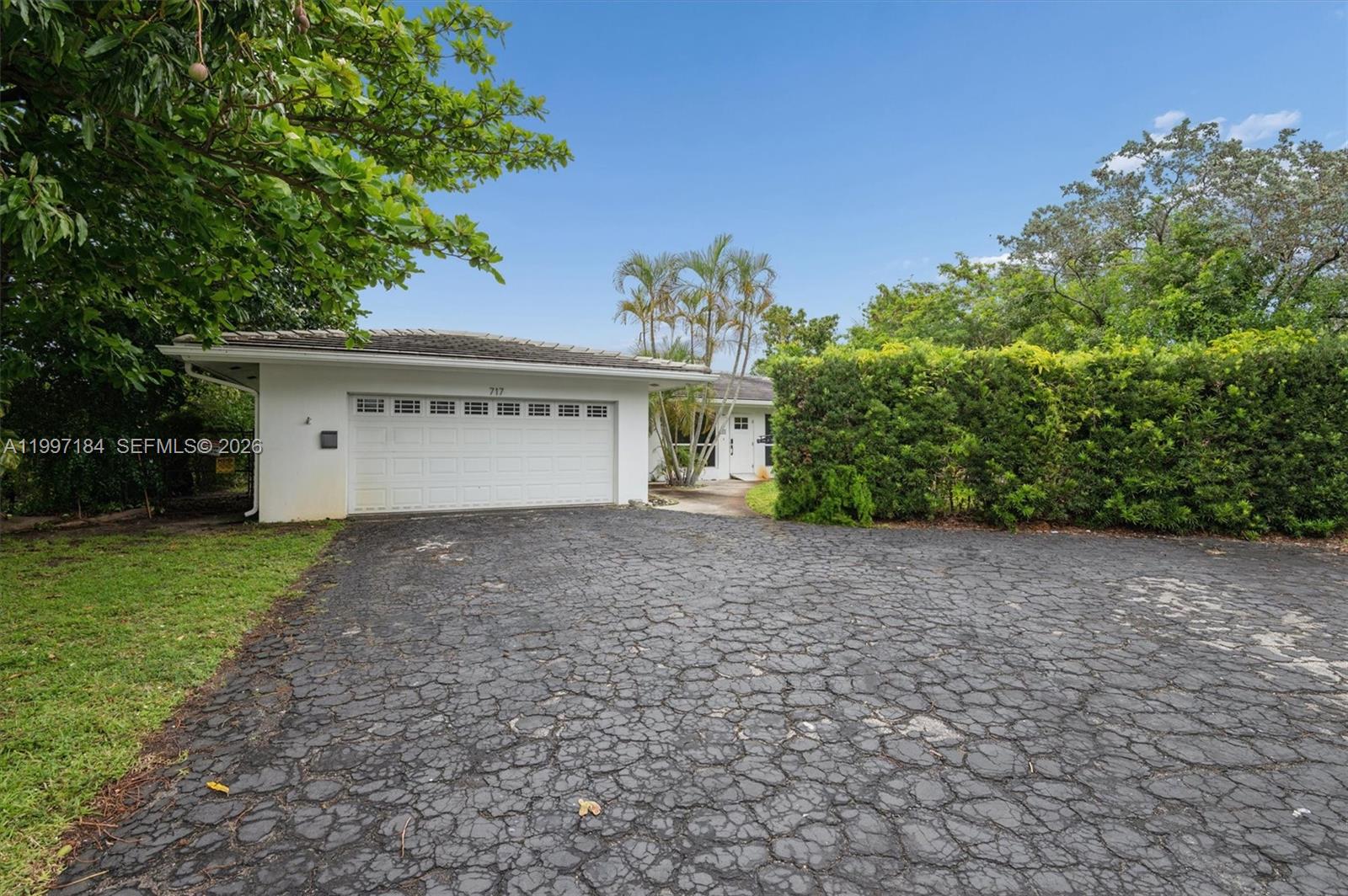 A white house with a garage and a large, cracked asphalt driveway — 717 NW 30th St, Wilton Manors FL 33311, WILTON MANORS, FL