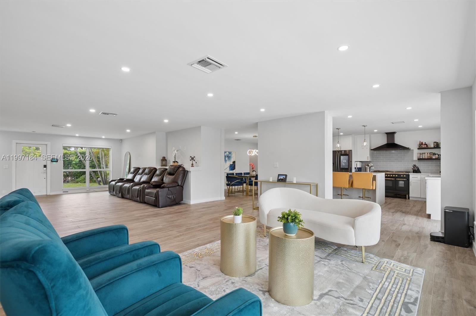 An open-concept living area features a kitchen, dining space, and two distinct seating areas — 717 NW 30th St, Wilton Manors FL 33311, WILTON MANORS, FL