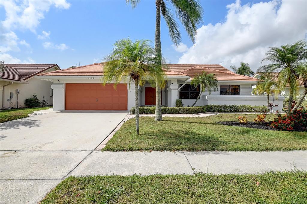 A single-story house with a terracotta tile roof, orange garage door, and palm trees — 9565 El Clair Ranch Road, Boynton Beach FL 33437, BOYNTON BEACH, FL