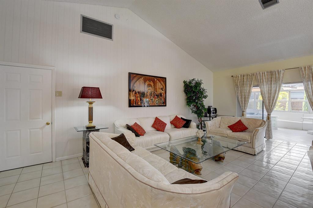 A living room features white tile floors, vaulted ceilings, and three cream-colored sofas — 9565 El Clair Ranch Road, Boynton Beach FL 33437, BOYNTON BEACH, FL
