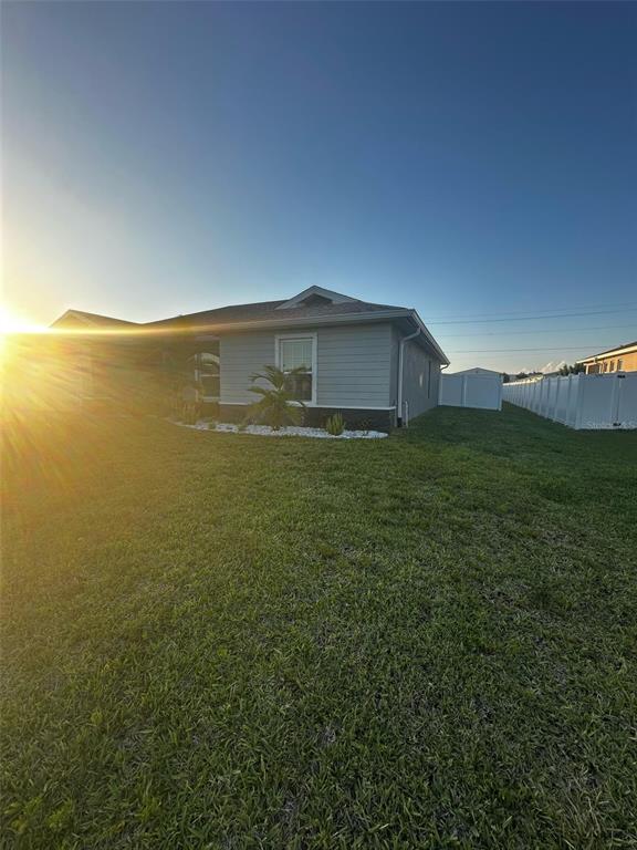 A view of the rear exterior of a single-story house with a fenced yard — 1501 NW 4TH STREET, CAPE CORAL, FL
