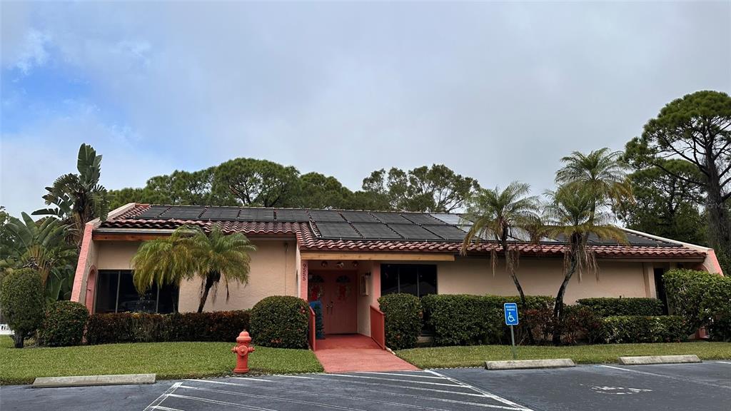 A single-story building with a red tile roof, solar panels, and a red fire hydrant — 9783 86TH AVENUE, SEMINOLE, FL