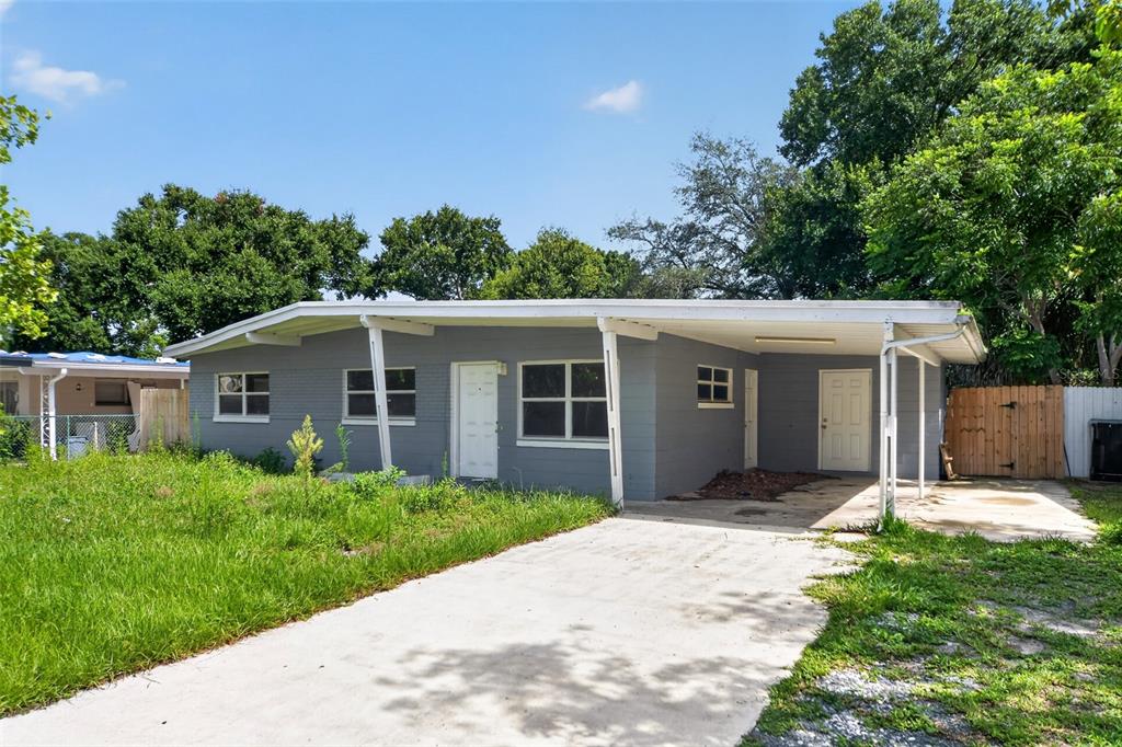 A gray, single-story house with a white front door and an attached carport — 4001 MONARCH DRIVE, ORLANDO, FL