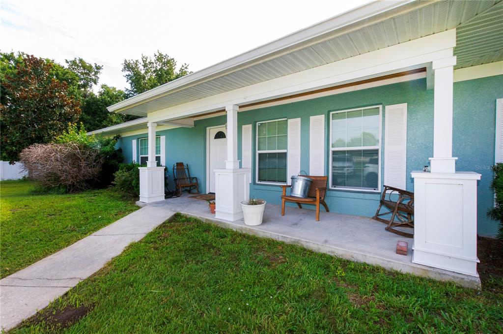A teal house with a covered front porch, white columns, and white window shutters — 3981 HICKORY TREE ROAD, ST CLOUD, FL