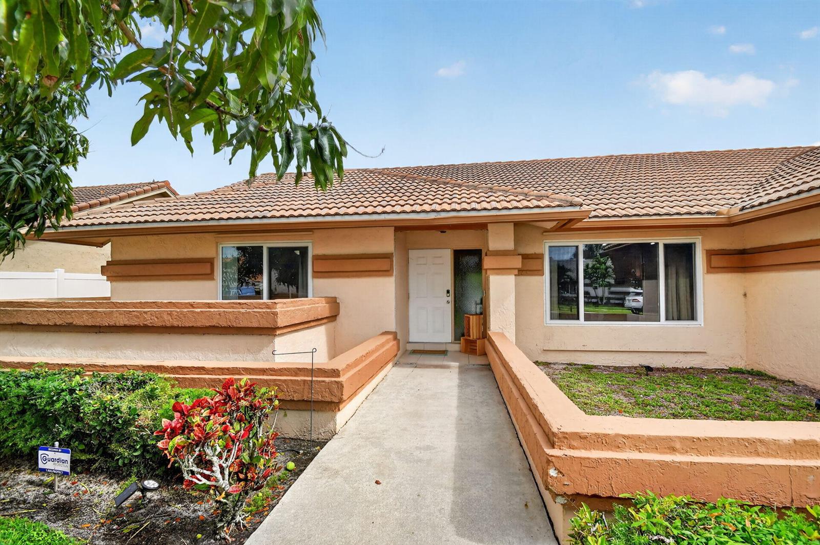 A single-story house with a beige stucco exterior, a tiled roof, and a concrete walkway — 9501 Majestic Way, Boynton Beach FL 33437, BOYNTON BEACH, FL