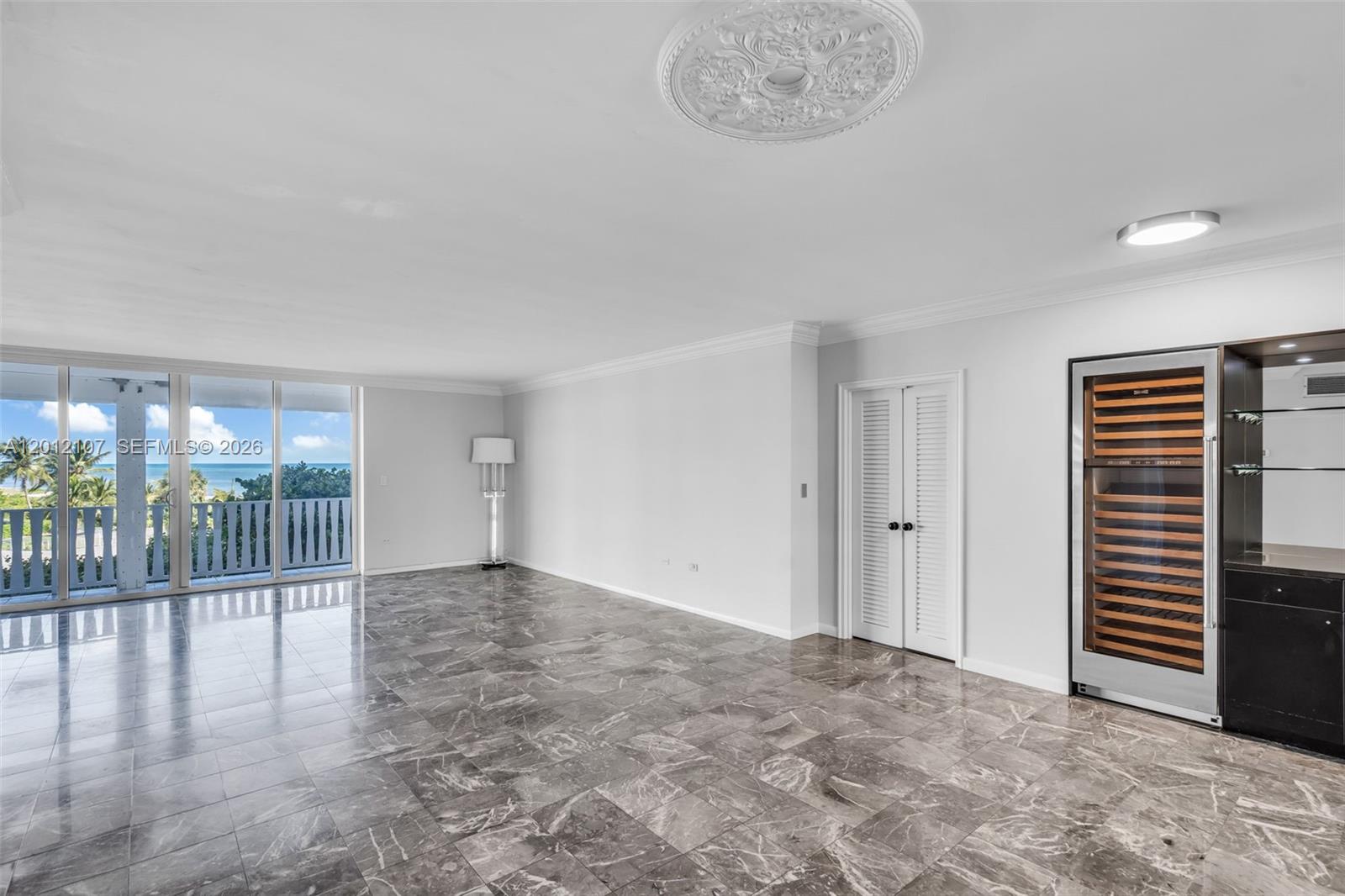 A spacious room features gray marble flooring, a wine cooler, and a balcony with ocean views — 200 Ocean Lane Dr # 407, Key Biscayne FL 33149, KEY BISCAYNE, FL