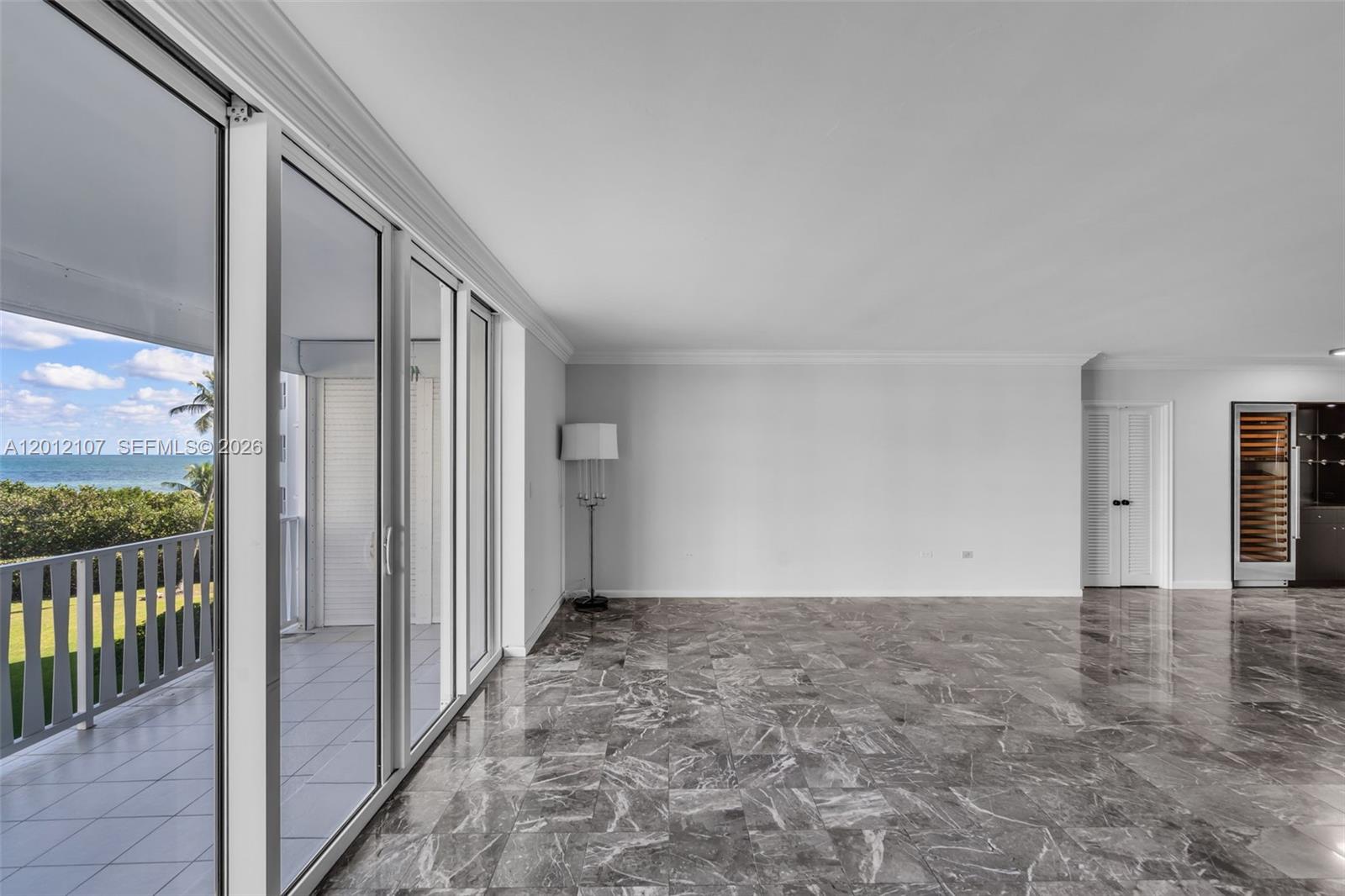 A spacious room features gray marble flooring, large sliding glass doors, and a wine cooler — 200 Ocean Lane Dr # 407, Key Biscayne FL 33149, KEY BISCAYNE, FL