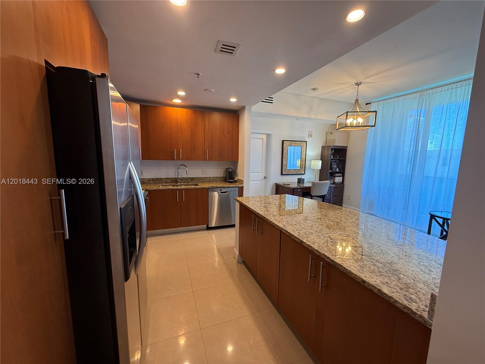 A kitchen features wood cabinets, granite countertops, stainless steel appliances, and tile flooring — 1945 S Ocean Dr # 312, Hallandale Beach FL 33009, HALLANDALE BEACH, FL