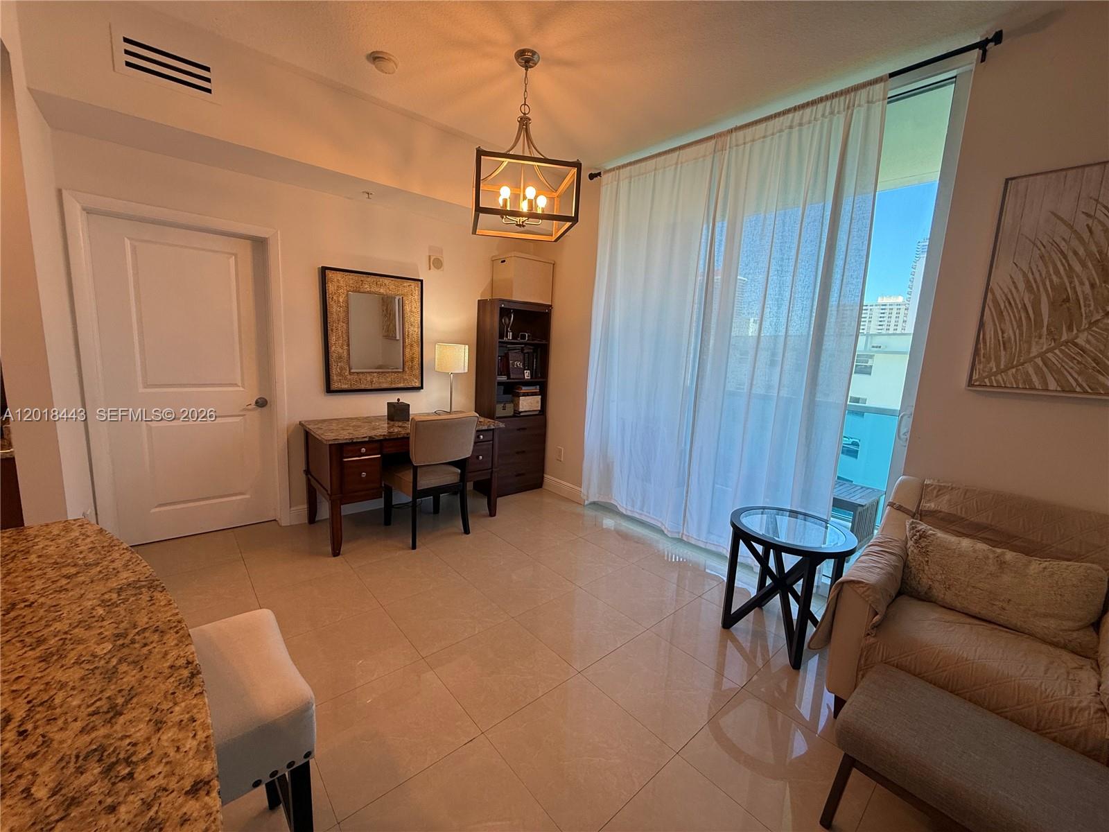 A room with tile floors, a desk, a sofa, and a large window with curtains — 1945 S Ocean Dr # 312, Hallandale Beach FL 33009, HALLANDALE BEACH, FL