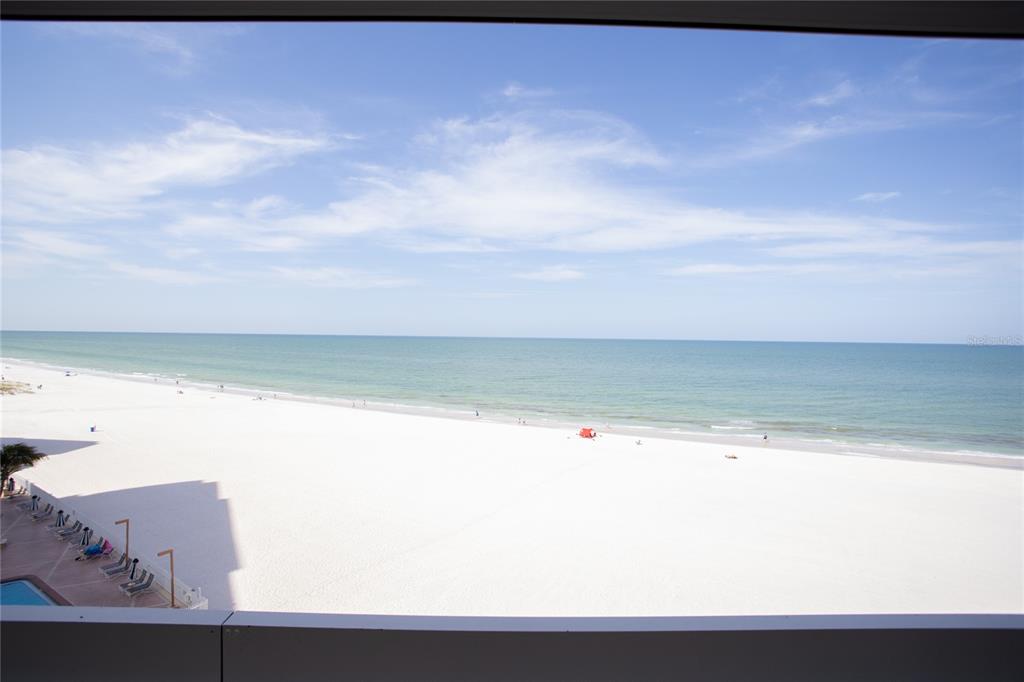 An elevated view of a white sand beach and the ocean from a balcony — 17940 GULF BOULEVARD UNIT 6E, REDINGTON SHORES, FL