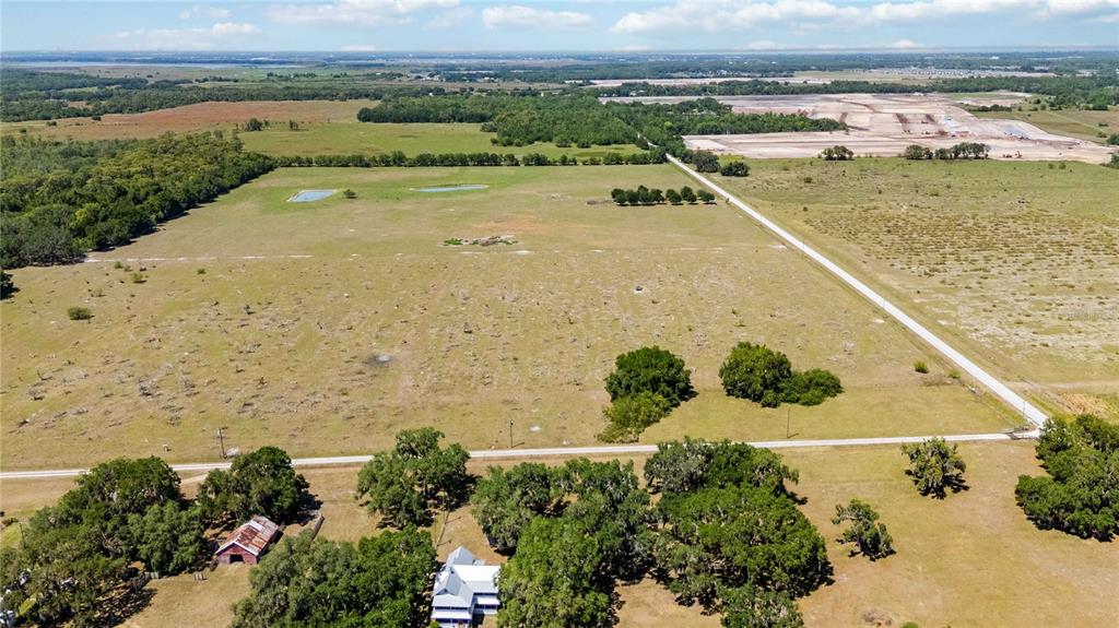 An aerial view shows a rural property with a house, barn, and large open fields — 0 LAKE TOHOPEKALIGA ROAD, ST CLOUD, FL