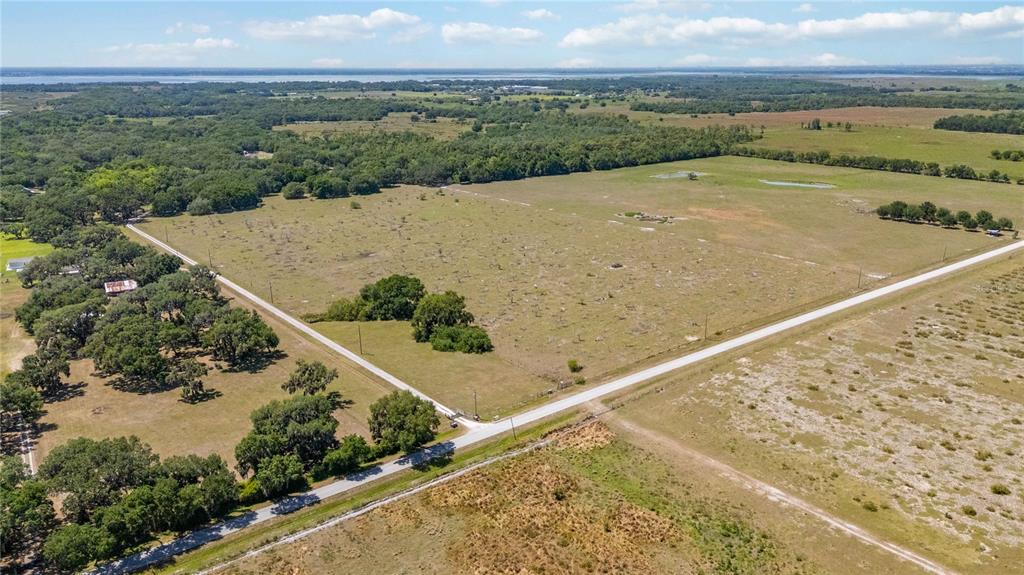 An aerial view shows a large, fenced plot of rural land with scattered trees — 0 LAKE TOHOPEKALIGA ROAD, ST CLOUD, FL