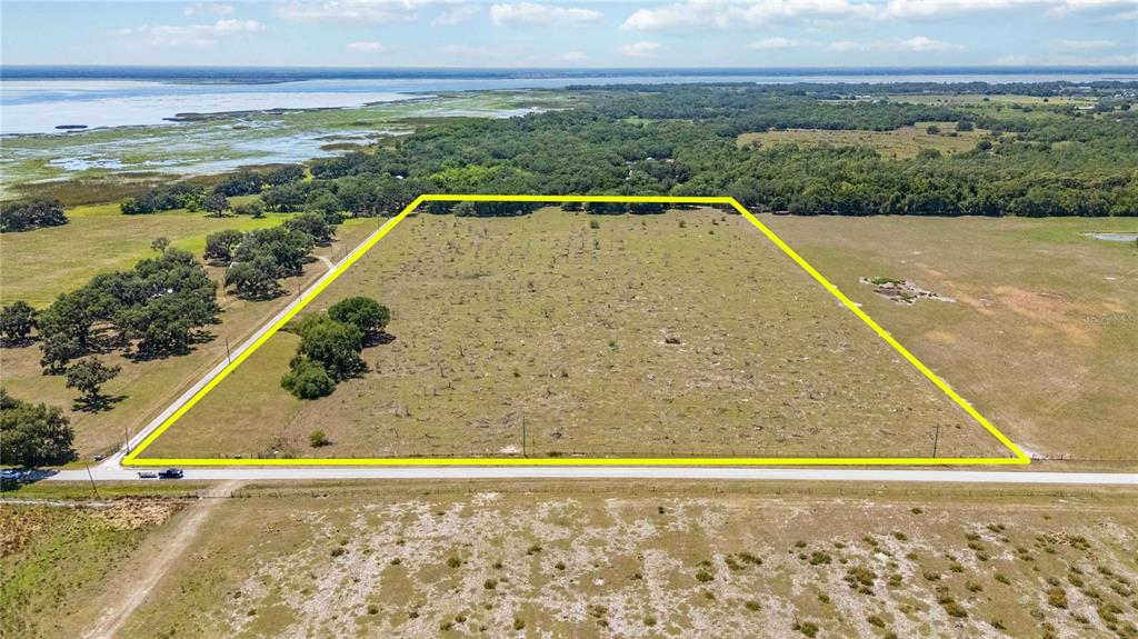 An aerial view shows a rectangular plot of land outlined in yellow near a lake — 0 LAKE TOHOPEKALIGA ROAD, ST CLOUD, FL