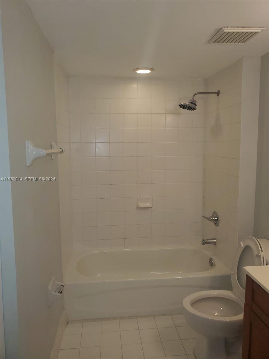 A bathroom features a white tiled bathtub and shower combination next to a toilet — 36 NW 6th Ave # 603, Miami FL 33128, MIAMI, FL