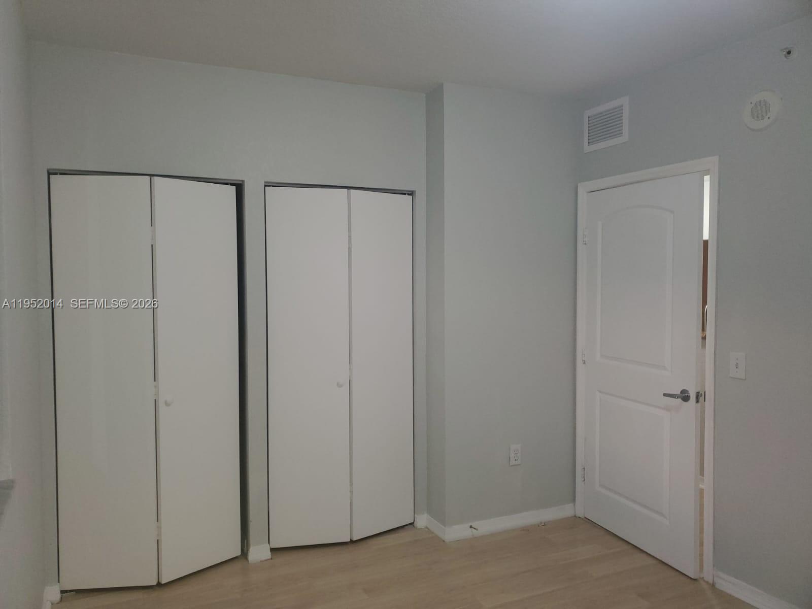 A room with light wood flooring, two white bifold closets, and a single interior door — 36 NW 6th Ave # 603, Miami FL 33128, MIAMI, FL