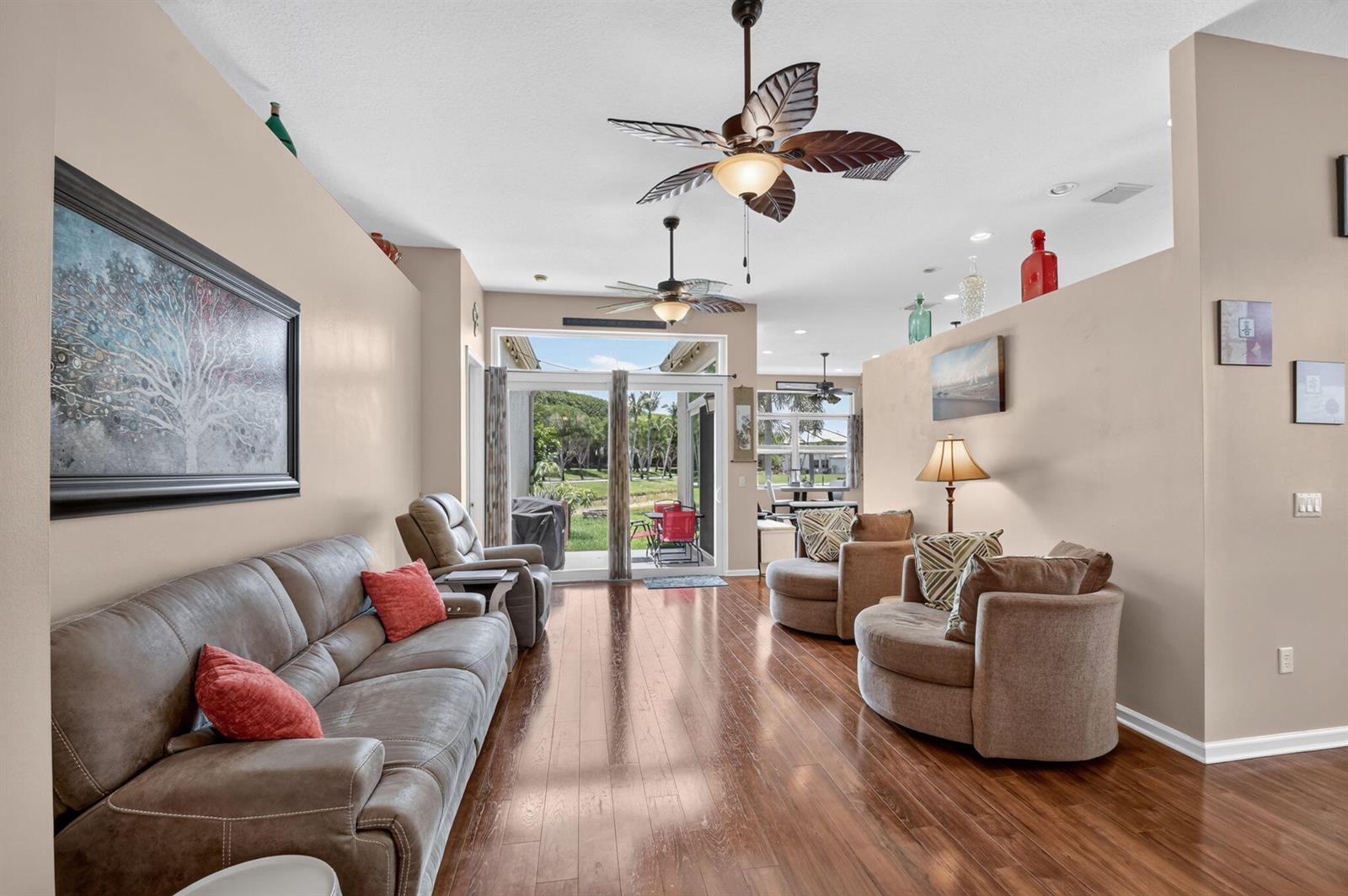 A living room with wood floors, two ceiling fans, and sliding glass doors to a patio — 2142 Balsan Way, Wellington FL 33414, WELLINGTON, FL