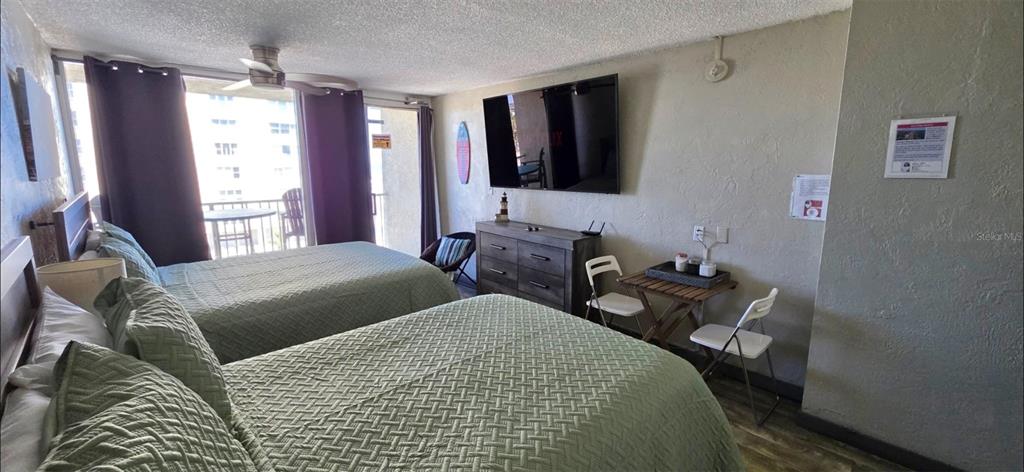 A hotel room features two beds, a wall-mounted television, a dresser, and a small table — 3501 S ATLANTIC AVENUE UNIT 5030, DAYTONA BEACH, FL