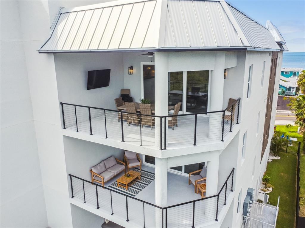 An elevated view of two stacked balconies with outdoor furniture and metal railings — 19505 GULF BOULEVARD UNIT 404, INDIAN SHORES, FL