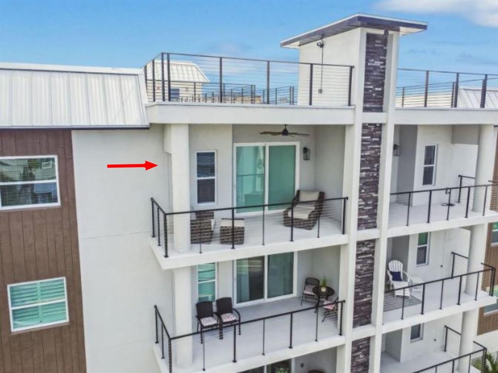 An exterior view of a multi-story building featuring balconies with metal railings and sliding doors — 19505 GULF BOULEVARD UNIT 404, INDIAN SHORES, FL
