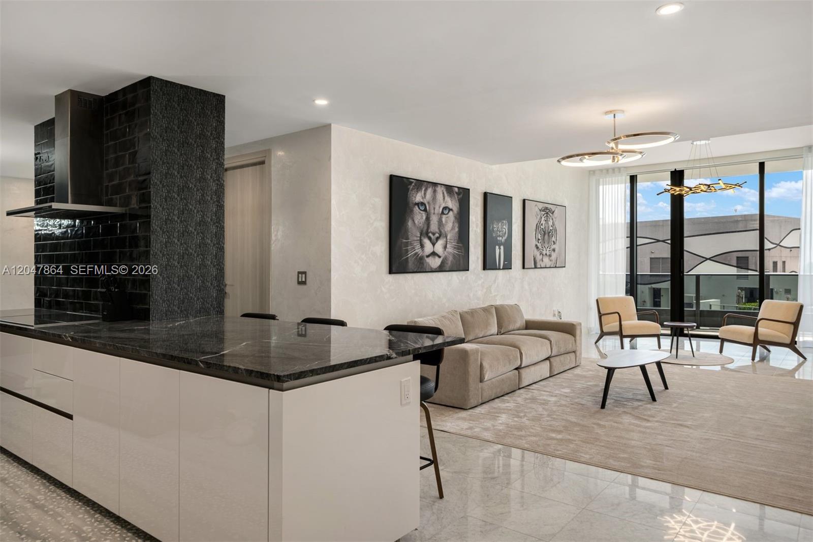 A modern open-concept living area features a kitchen island, neutral sofa, and animal wall art — 1000 Brickell Plz, Miami FL 33131, MIAMI, FL