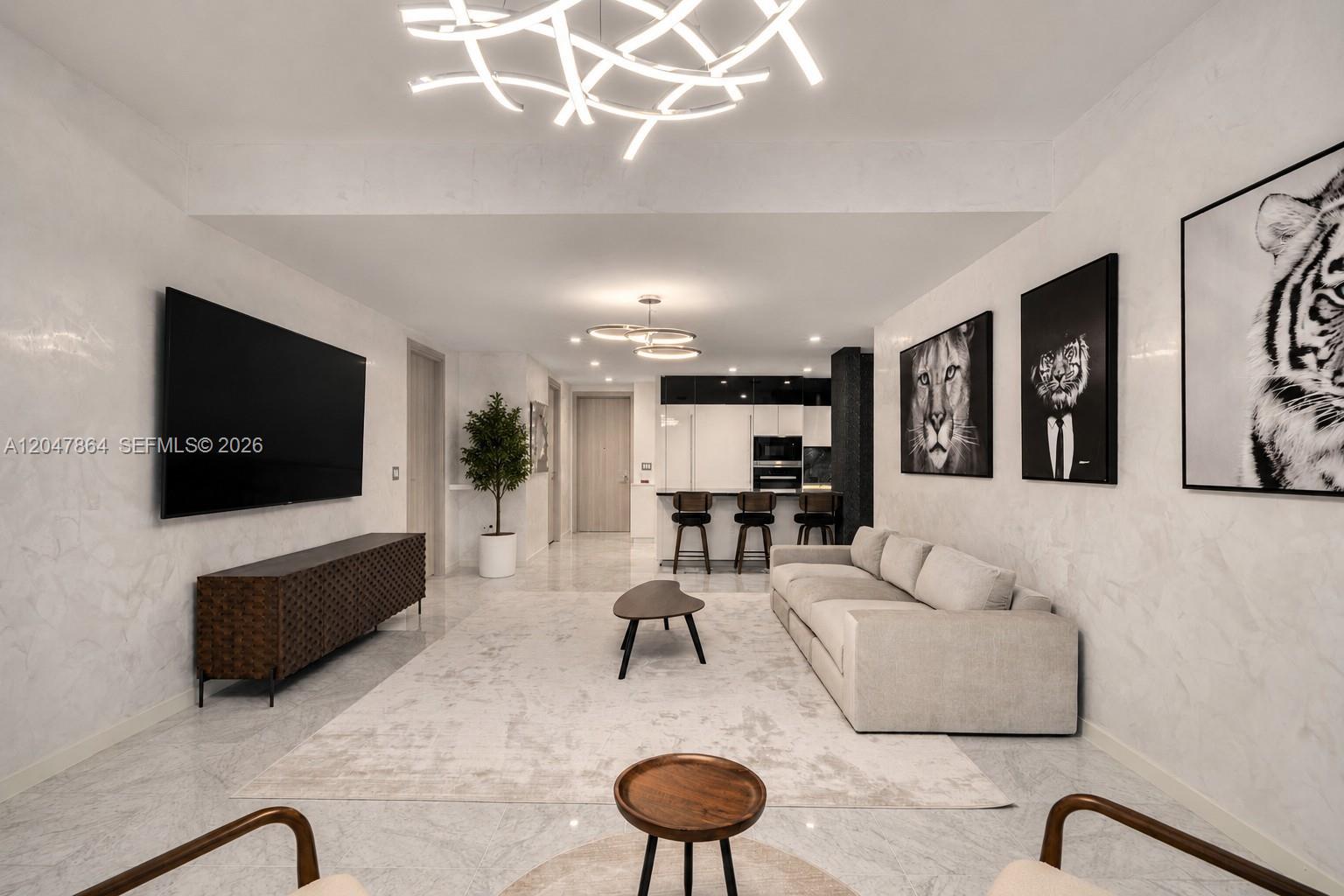 A modern living room features a large television, a light-colored sofa, and animal-themed wall art — 1000 Brickell Plz, Miami FL 33131, MIAMI, FL