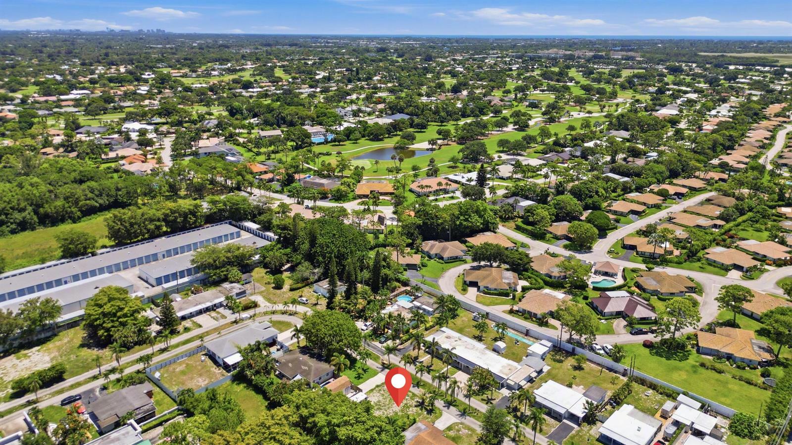 An aerial view shows a vacant residential lot marked with a red pin in a neighborhood — 000 Morrison Avenue, FL 33463, FL
