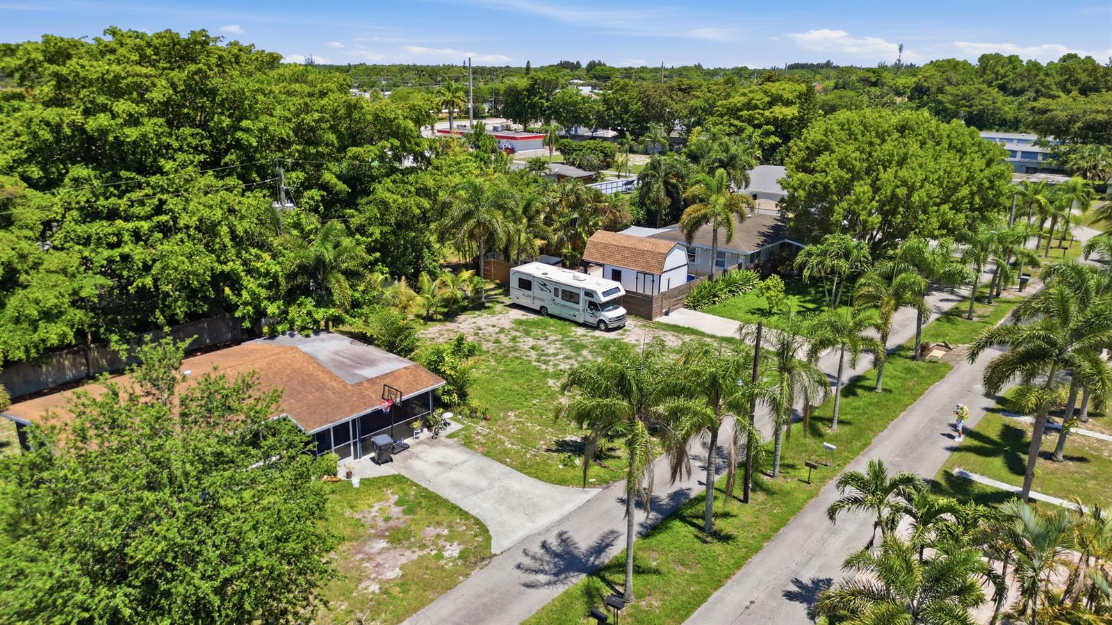 An aerial view shows a house with a brown roof, a parked RV, and palm trees — 000 Morrison Avenue, FL 33463, FL