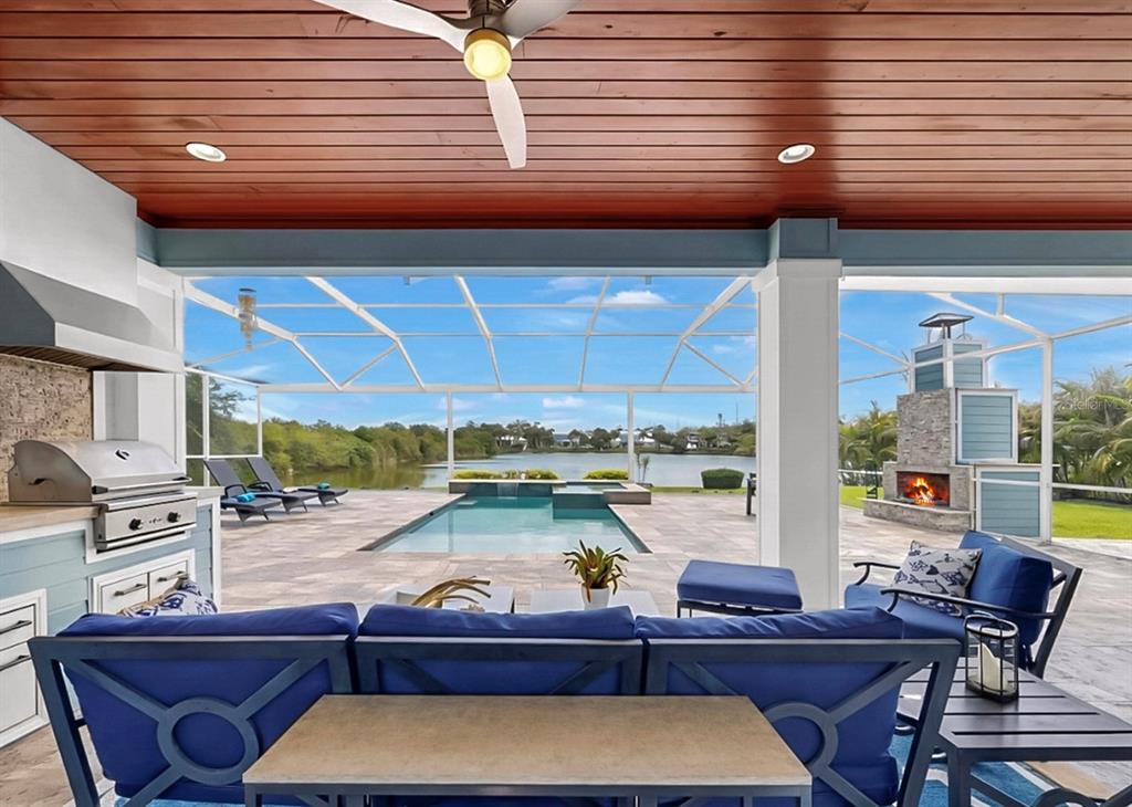 A screened-in patio features a rectangular swimming pool, stone pavers, and a lake view — 8013 KEY WEST CONCH DRIVE, RIVERVIEW, FL