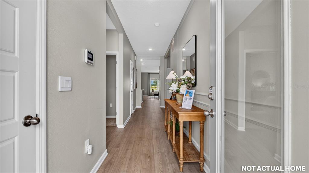 This is a rendering of a hallway with wood-look flooring and a wooden console table — 238 HAWTHORN AVENUE, PALM COAST, FL