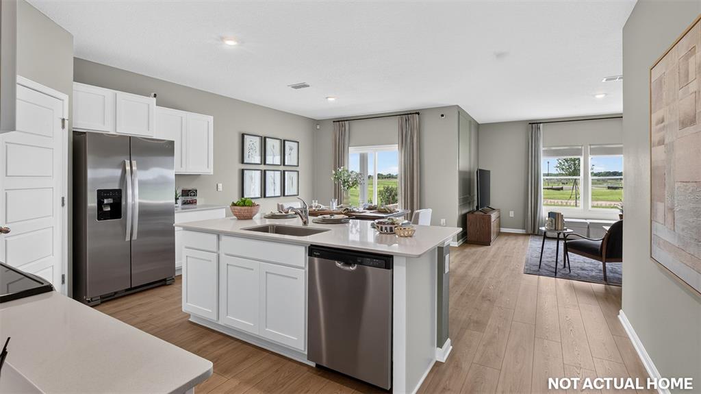 This rendering shows a modern kitchen with a center island, stainless appliances, and light flooring — 238 HAWTHORN AVENUE, PALM COAST, FL