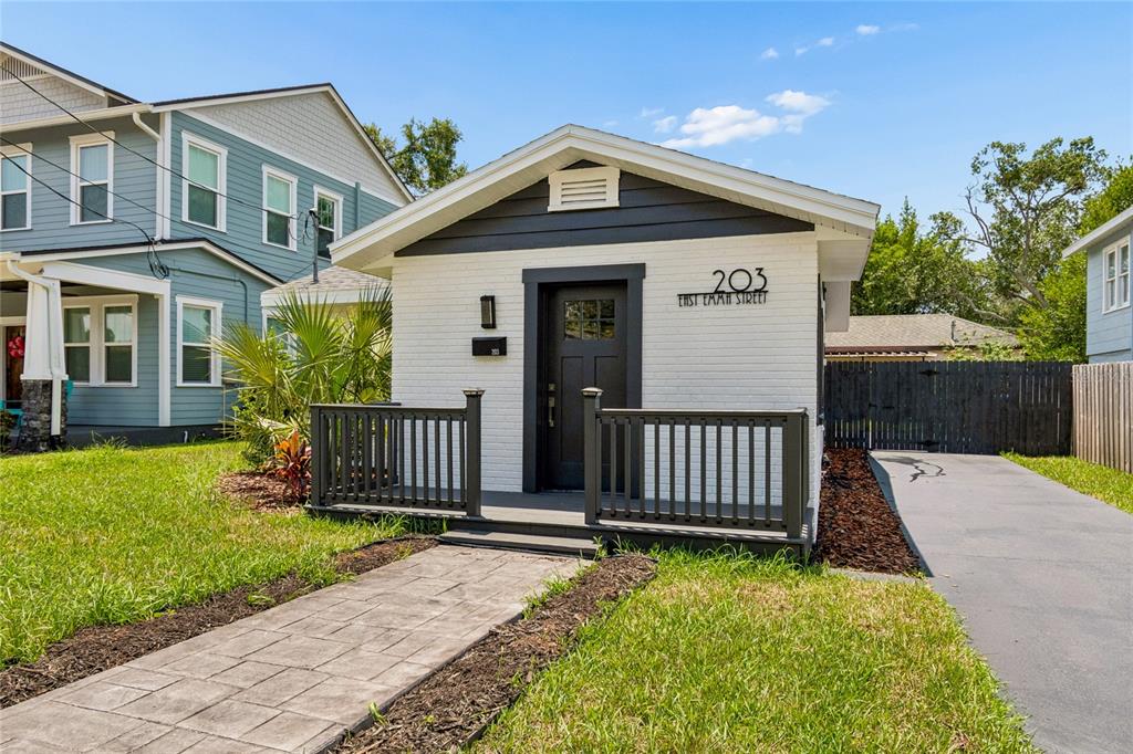 A small white brick house with a dark front door and a wooden porch — 203 E EMMA STREET, TAMPA, FL