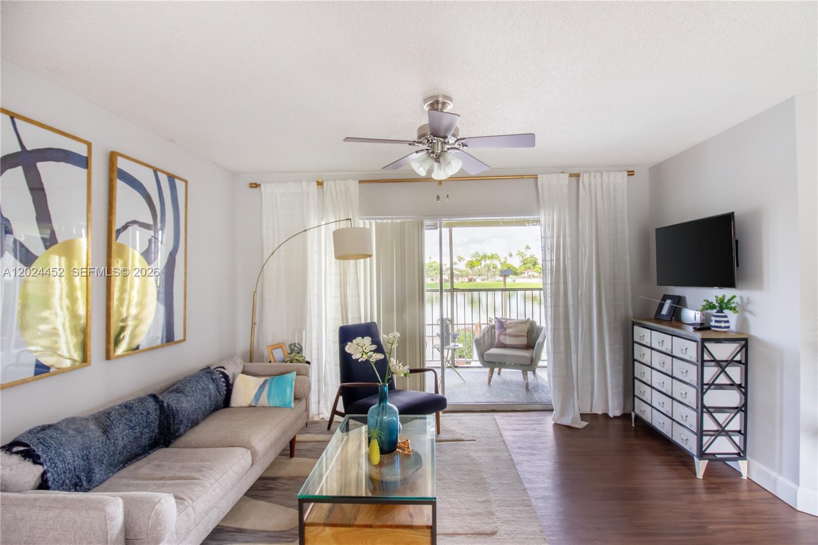 A living room features a sofa, glass coffee table, and sliding doors opening to a balcony — 17230 NW 64th Ave, Miami Lakes FL 33015, MIAMI LAKES, FL