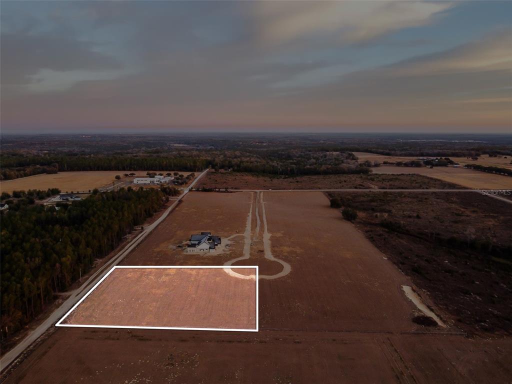 An aerial view shows a rectangular plot of land outlined in white near a house — 4135 ROYAL SKY (LOT 9) COURT, BROOKSVILLE, FL
