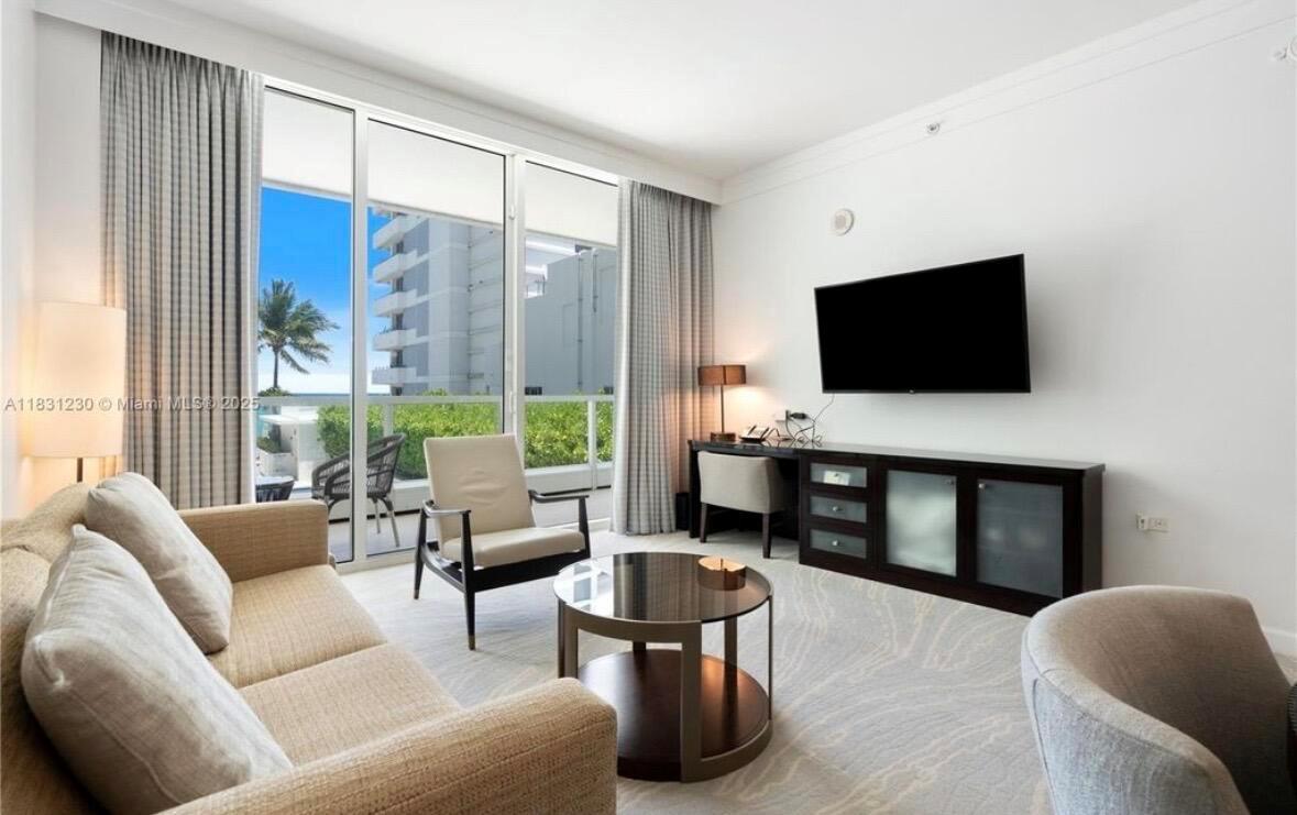A living room features a sofa, armchairs, a coffee table, and a balcony with ocean views — 4391 Collins Avenue Unit 623, Miami Beach FL 33140, MIAMI BEACH, FL