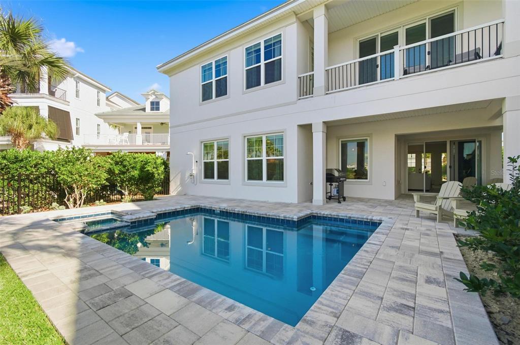 A two-story house exterior features a backyard swimming pool and a paved patio area — 527 CINNAMON BEACH LANE, PALM COAST, FL