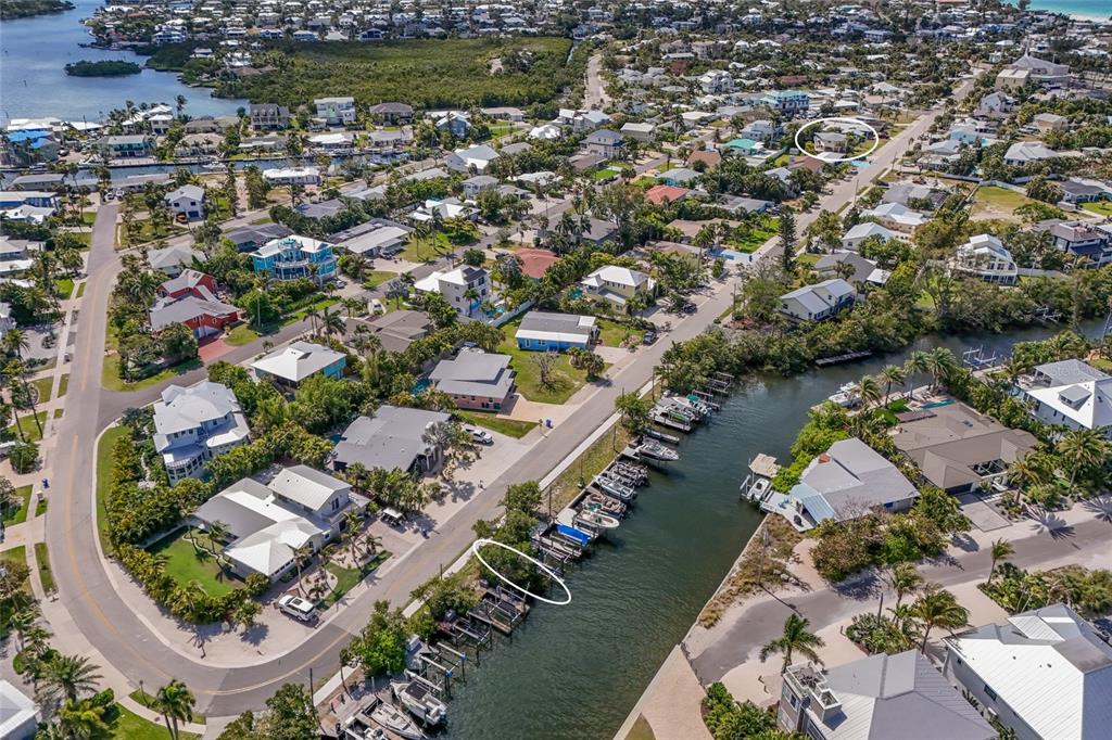An aerial view shows a residential neighborhood with a canal lined with boats — 221 85TH STREET, HOLMES BEACH, FL